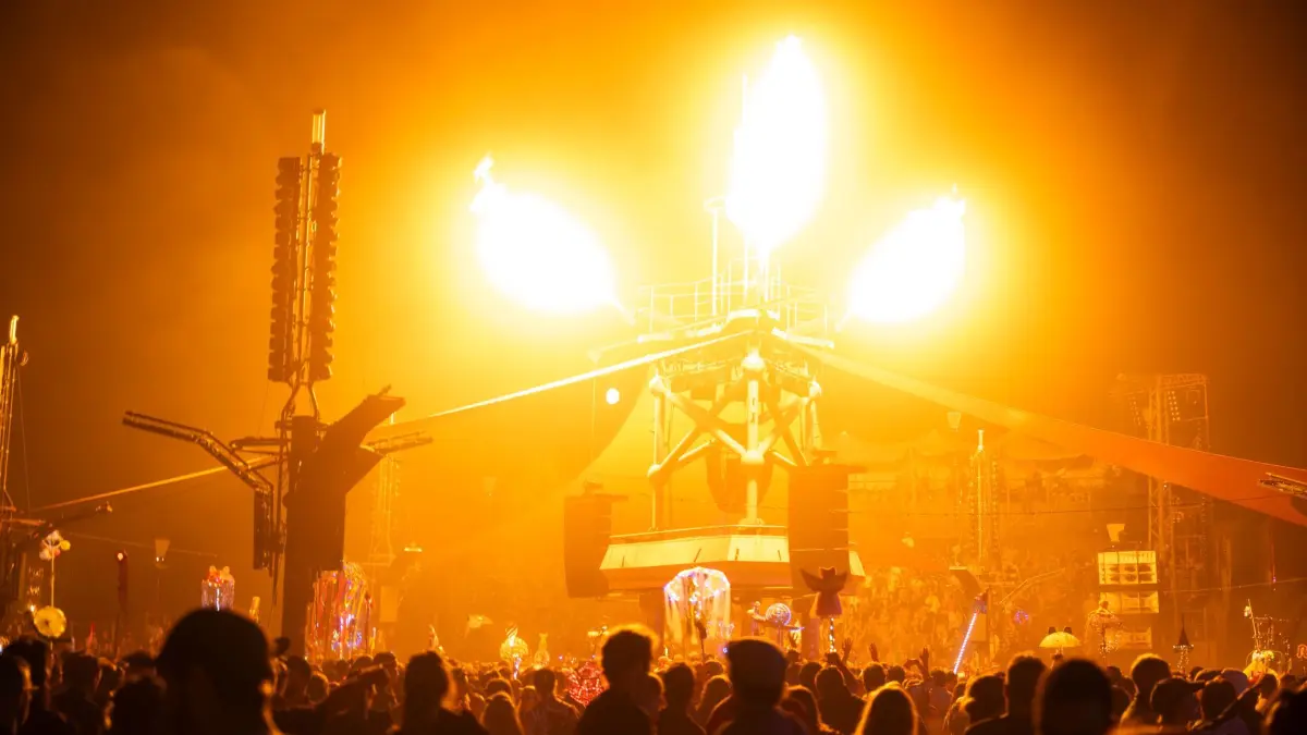 Fusion-Festival 2026: 25.06.2026, Mecklenburg-Vorpommern, Lärz: Lichteffekte leuchten an der Turmbühne auf dem Fusion-Festival. Wegen Bränden außerhalb des Geländes war das Festival unterbrochen worden. Bis Sonntag sollen dort mehr als 3.300 Künstlerinnen und Künstler auftreten. Die Veranstalter rechnen mit 65.000 Besuchern. Das jährlich veranstaltete Festival an der Mecklenburgischen Seenplatte gilt als eines der größten alternativen Musik- und Kulturfestivals Europas. Foto: Philip Dulian/dpa +++ dpa-Bildfunk +++