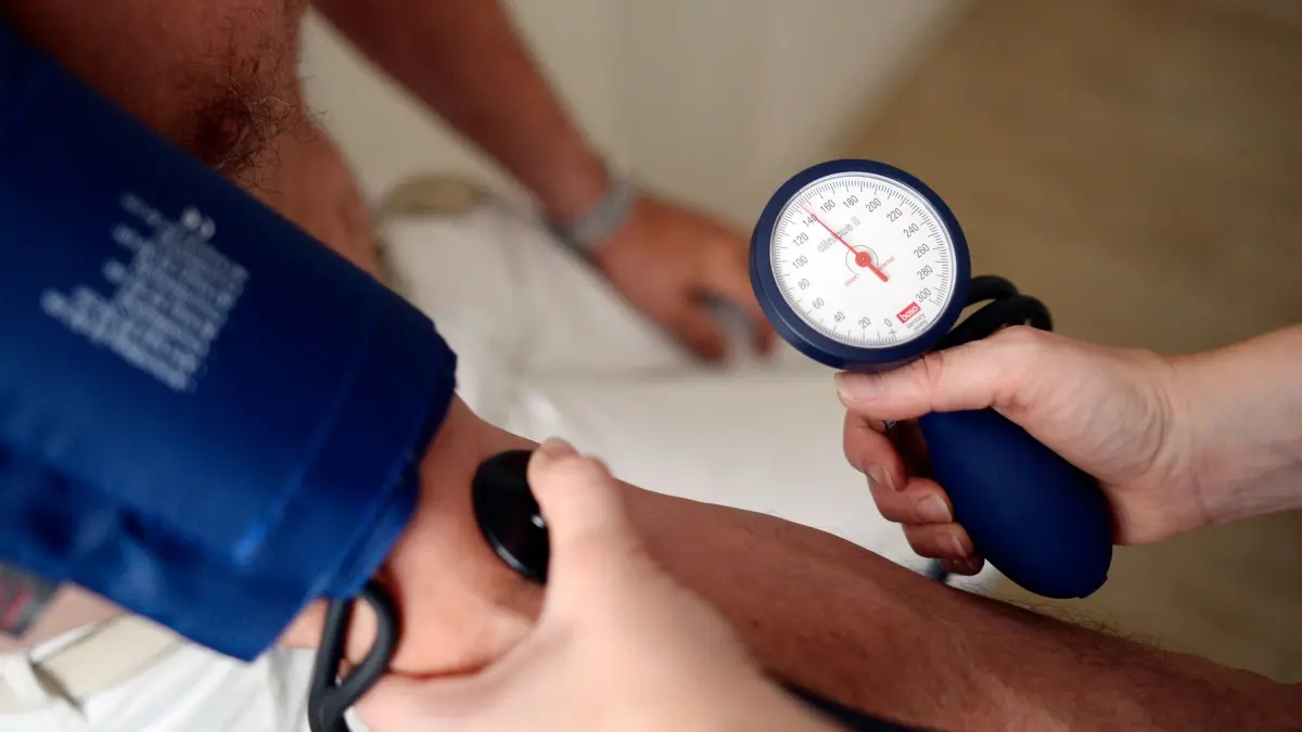 Symbolbild Hausarzt: ILLUSTRATION - 27.07.2016, Nordrhein-Westfalen, Minden: Eine Medizinerin misst den Blutdruck eines Patienten. Die Landesregierung Baden-Württemberg will mit einem neuen Konzept mehr Medizinstudierende für den Arztberuf auf dem Land interessieren. (zu dpa: «Kreislaufprobleme und mehr durch Hitze - Was Ärzte empfehlen») Foto: Maurizio Gambarini/dpa +++ dpa-Bildfunk +++