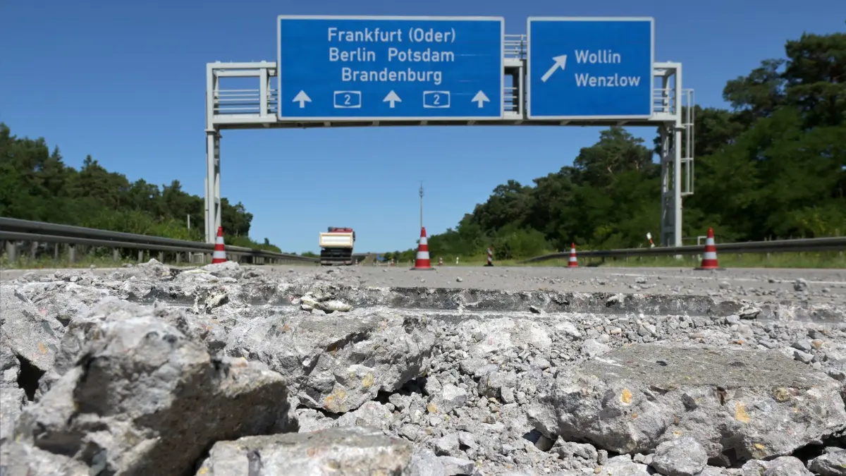 Hitze in Deutschland - Straßenschäden A2 in Brandenburg: 26.06.2026, Brandenburg, Wollin: Wenige Meter vor der Abfahrt Wollin der A2 in Richtung Berlin haben sich Teile der Betonfahrbahn gegeneinander geschoben, im Vordergrund liegen aufgebrochene Betonbrocken neben der Fahrspur. Durch den Druck bei den hohen Temperaturen der derzeitigen Hitzewelle zerbrachen die Betonplatten an den Übergängen, Betonteile wurden zum Teil mehrere Meter weit geschleudert; zahlreiche Fahrzeuge, die über die Stelle fuhren, wurden beschädigt. Foto: Michael Bahlo/dpa +++ dpa-Bildfunk +++