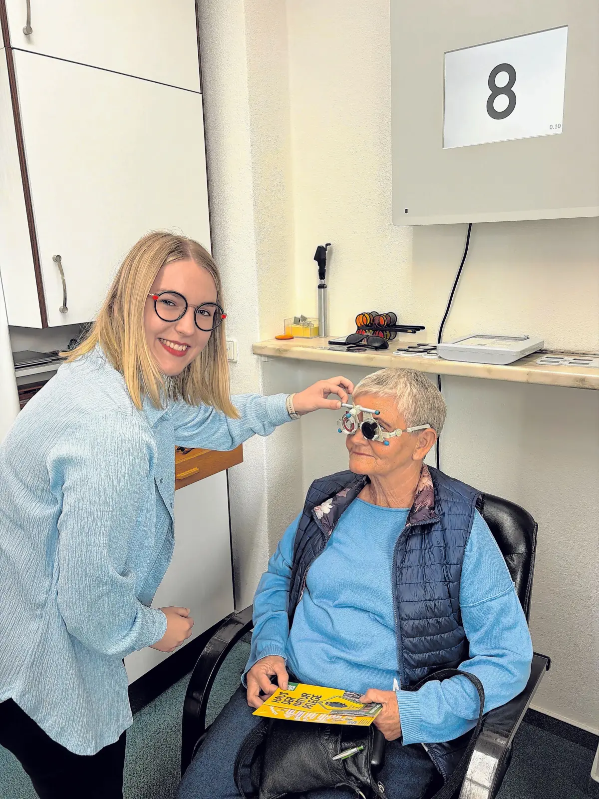 Modernste Messtechnik: Luise Kroll beim Polatest mit einem Sehprüfgerät in Durchlichtbauweise für die Sehschärfebestimmung und die subjektive Brillenglasbestimmung