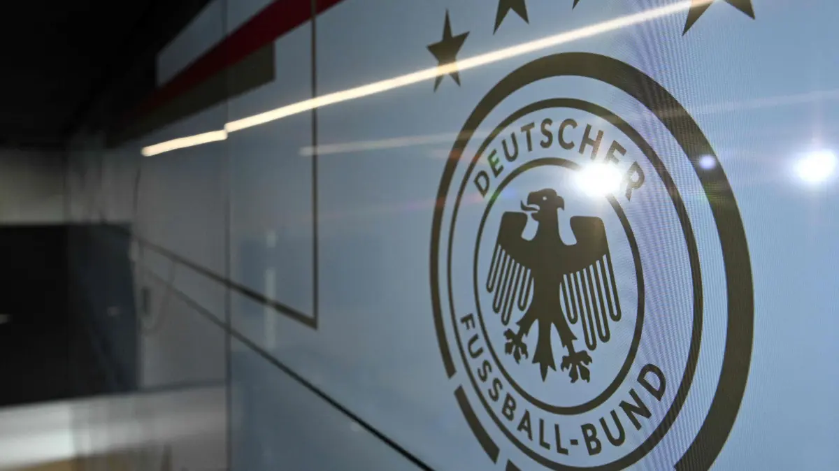 -: (FILES) This file photo taken on September 22, 2023 shows the logo of the German Football Federation (DFB) during a press conference at the DFB headquarters in Frankfurt, western Germany. Investigators raided Germany's football association headquarters and other locations across the country on July 1, 2026 as part of an investigation into corruption linked to the Euro 2024 tournament. The DFB confirmed that its headquarters in Frankfurt had been targeted. The case involves allegations that employees of German host cities were illegally invited to Euro matches and received tickets on favourable terms from the organisers, police and prosecutors said. (Photo by Kirill KUDRYAVTSEV / AFP)