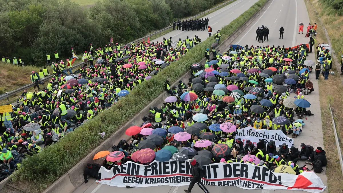 Bundesparteitag der AfD: 04.07.2026, Thüringen, Erfurt: Demonstranten protestieren auf der Autobahn A71 bei Gottstedt gegen den AfD-Bundesparteitag. Der Bundesparteitag der AfD findet am 4. und 5. Juli in der Messe Erfurt statt. Foto: Michael Reichel/dpa +++ dpa-Bildfunk +++