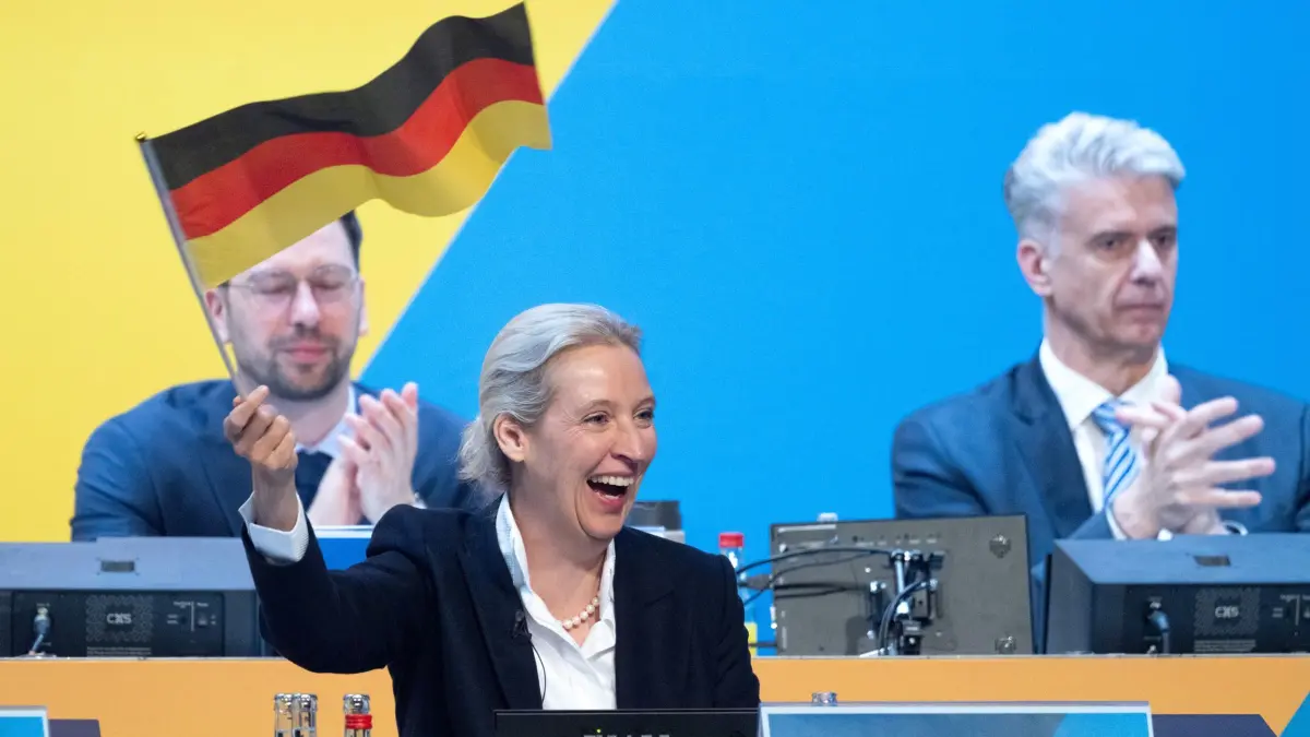 Bundesparteitag der AfD: 04.07.2026, Thüringen, Erfurt: Alice Weidel, Bundesvorsitzende und Fraktionsvorsitzende der AfD, schwenkt eine Deutschland-Fahne während des Bundesparteitags der AfD. Bei dem Treffen soll die Führungsspitze der Partei neu gewählt werden. Der Bundesparteitag der AfD findet am 4. und 5. Juli findet in der Messe Erfurt statt. Foto: Sebastian Kahnert/dpa +++ dpa-Bildfunk +++