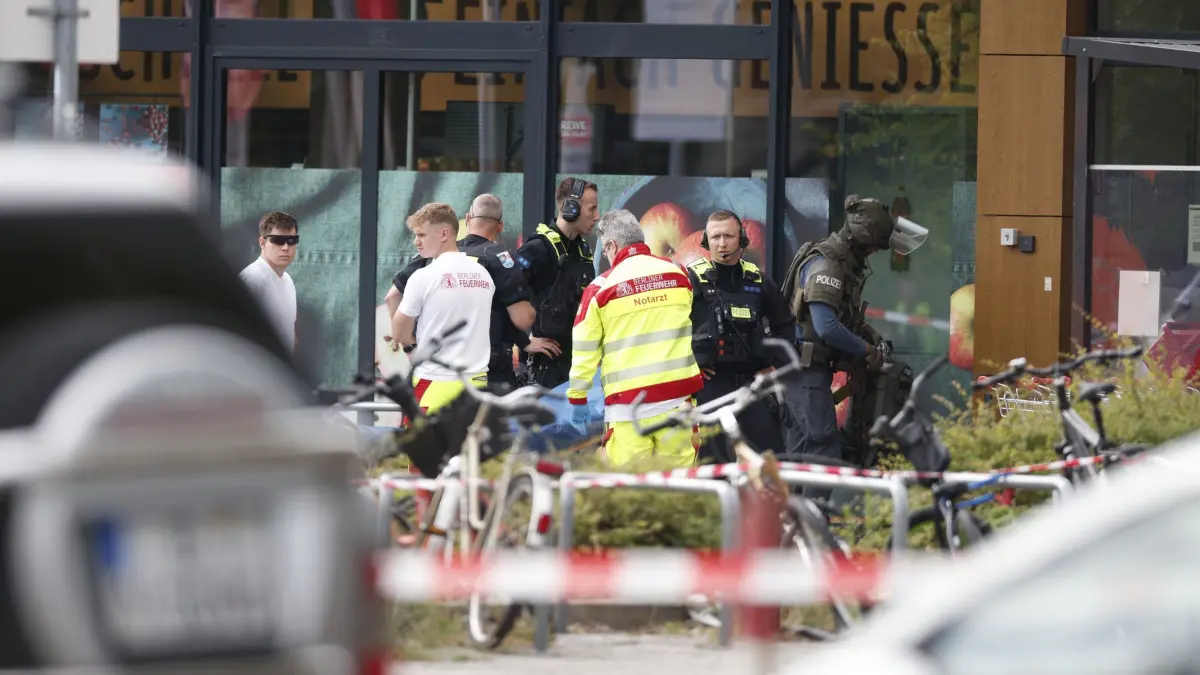 Geiselnahme in Berliner Supermarkt: 11.07.2026, Berlin: Einsatzkräfte stehen vor einem Supermarkt neben einer verletzten Person auf einer Trage. In dem Supermarkt im Süden Berlins hielt ein Mann seit dem späten Freitagabend (10.07.2026) eine Frau als Geisel. Die Geiselnahme wurde durch die Polizei beendet. Foto: Carsten Koall/dpa +++ dpa-Bildfunk +++