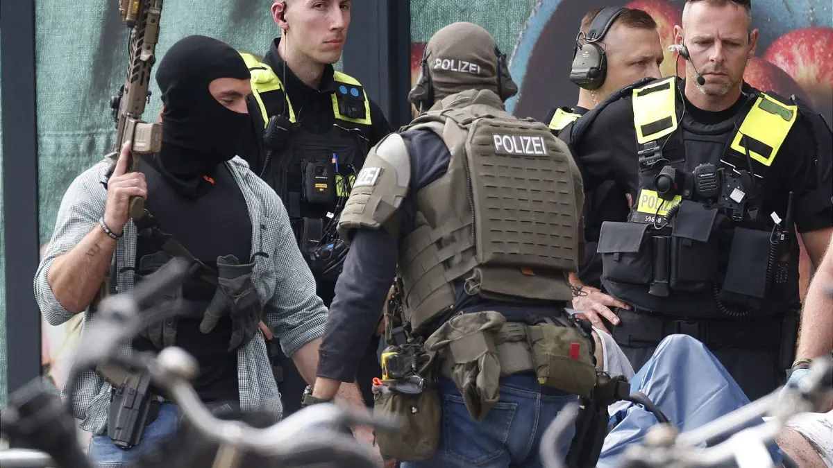 Geiselnahme in Berliner Supermarkt: 11.07.2026, Berlin: Einsatzkräfte stehen vor einem Supermarkt neben einer verletzten Person auf einer Trage. In dem Supermarkt im Süden Berlins hielt ein Mann seit dem späten Freitagabend (10.07.2026) eine Frau als Geisel. Die Geiselnahme wurde durch die Polizei beendet. Foto: Carsten Koall/dpa +++ dpa-Bildfunk +++