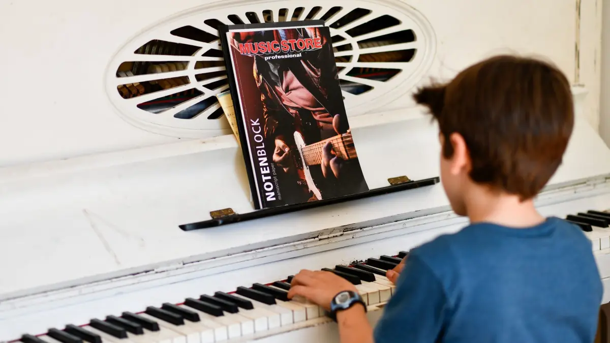 Kind spielt Klavier: ILLUSTRATION - Wie viel Aktivitäten von Musik bis Sport nach einem langen Schultag noch drin sind, müssen Eltern und Kinder gemeinsam herausfinden. (zu dpa: «Einschulung: Diese Herausforderungen warten auf Ersti-Eltern») Foto: Kirsten Neumann/dpa-tmn - Honorarfrei nur für Bezieher des dpa-Themendienstes +++ dpa-Themendienst +++