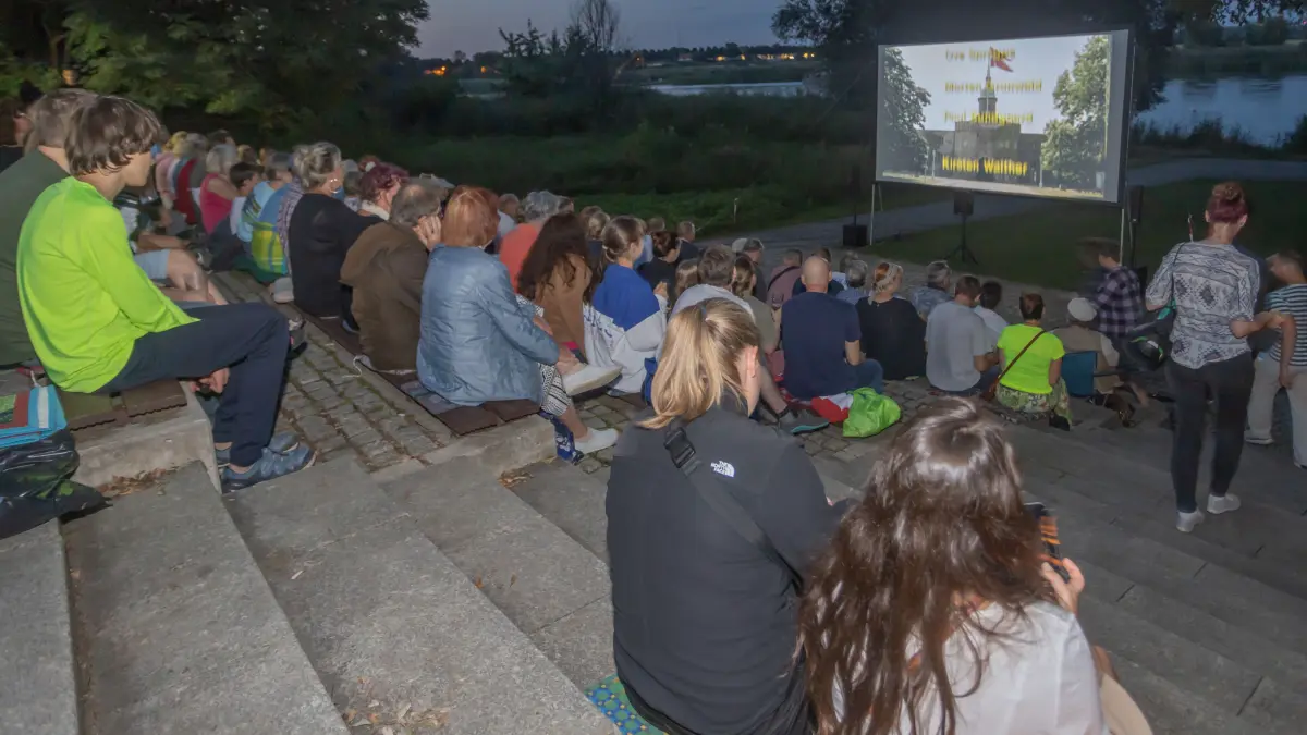 Sommerfilmtage: Idyllischer kann ein Kinoabend kaum sein, wenn in der Nachtdämmerung mit Blick auf die Oder ein Film über die Leinwand flimmert. Und das fast ohne Mücken. Der Start des Sommerprogramms des Vereins Kleines Kino in diesem Jahr darf als geglückt gelten. Der Film "Die Olsenbande steigt aufs Dach", lockte so viele Zuschauer auf die Insel Ziegenwerder wie selten zuvor. Kein Platz mehr frei, aber zum Glück gibt es ja noch Treppen zum Sitzen, war das Fazit an der Kasse gegen 21 Uhr beim Filmstart. Noch bis Samstagabend gibt es je eine Vorstellung. .