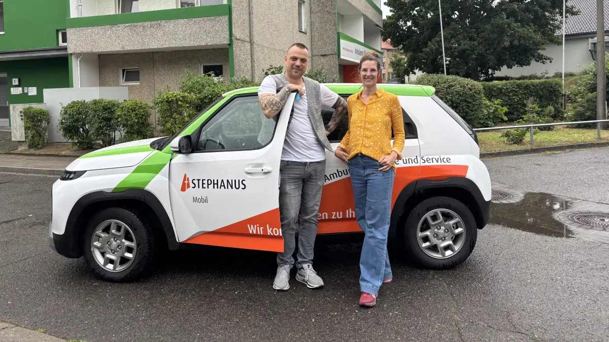 Wie viel trinken bei Hitze: Katharina Golde, Zentrale Qualitätsbeauftragte Stephanus gGmbH Geschäftsbereich Wohnen und Pflege, und Steven Stumowski, Leiter Stephanus-Mobil in Bad Freienwalde, vor einem der neuen Elektroautos des Pflegedienstes. Wieviel Senioren bei Hitze trinken sollten.
