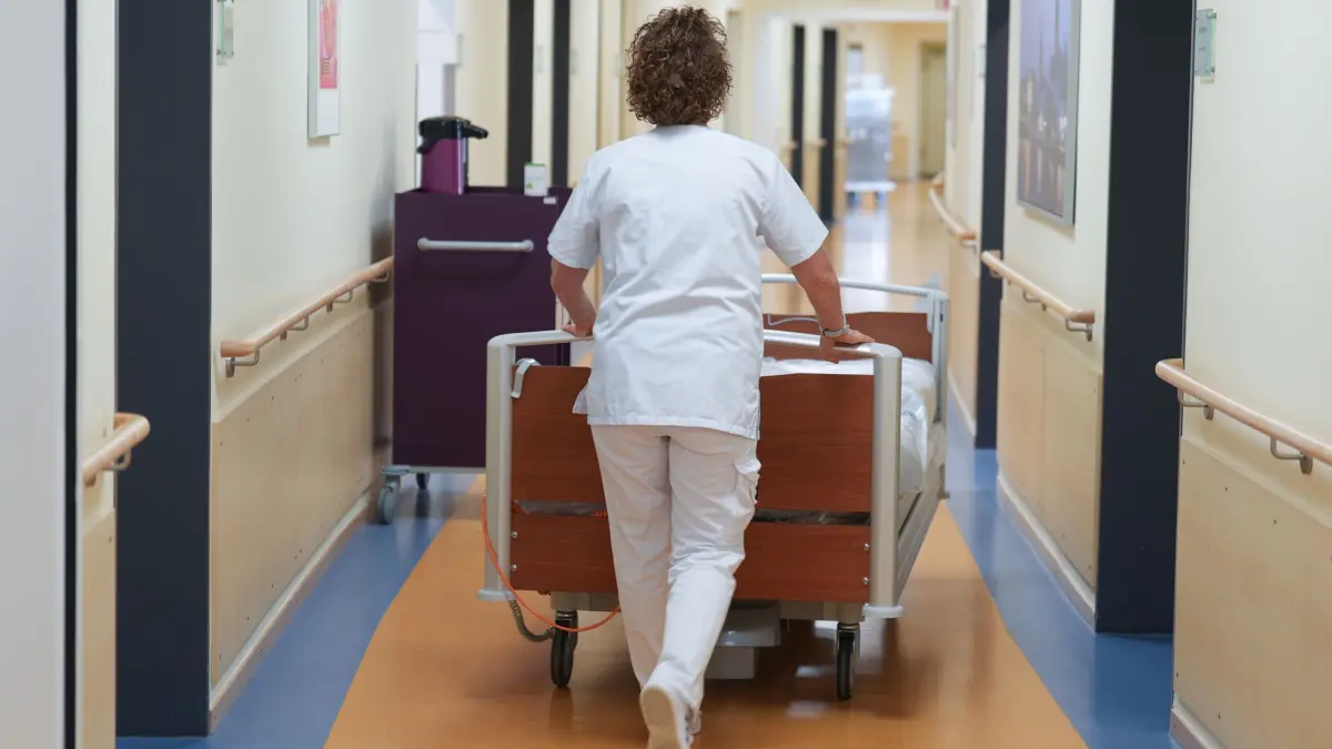 Krankenhaus: ARCHIV - 24.03.2025, Schleswig-Holstein, Bad Oldesloe: Eine Krankenschwester schiebt ein Bett über den Flur einer Krankenstation in der Asklepios Klinik Bad Oldesloe. (zu dpa: «Verkleidet als Krankenschwester: Patientin klaut Medikamente») Foto: Marcus Brandt/dpa +++ dpa-Bildfunk +++