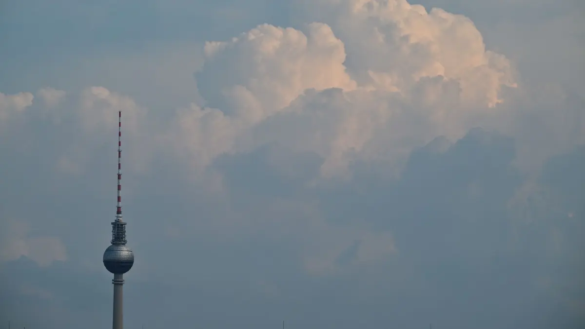Wetter in Berlin: 17.07.2026, Berlin: Hohe Wolken türmen sich hinter dem Fernsehturm südlich der Stadt auf. In Berlin kann es am Freitag zu Unwettern kommen. Foto: Sebastian Gollnow/dpa +++ dpa-Bildfunk +++