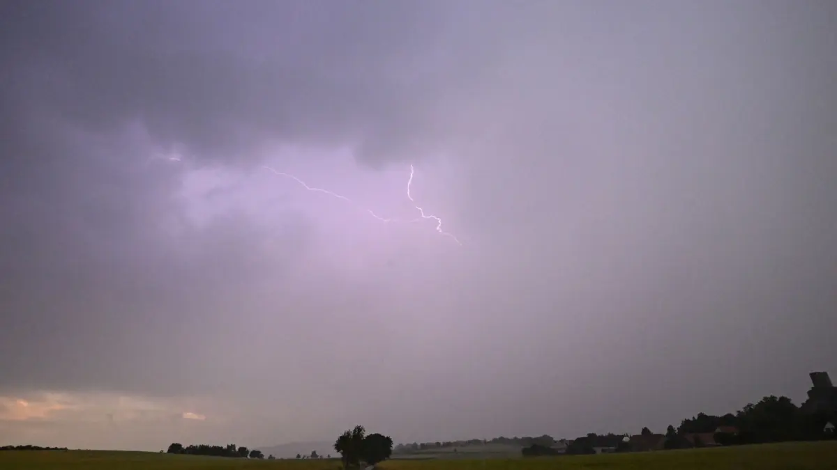 Hitze in Deutschland - Gewitter über Hessen: ARCHIV - 21.06.2026, Hessen, Münzenberg: Ein Blitz leuchtet vor dunklen Gewitterwolken über der Burgruine Münzenberg. (zu dpa: «Gewitter und Unwetter in Hessen erwartet») Foto: Florian Wiegand/dpa +++ dpa-Bildfunk +++