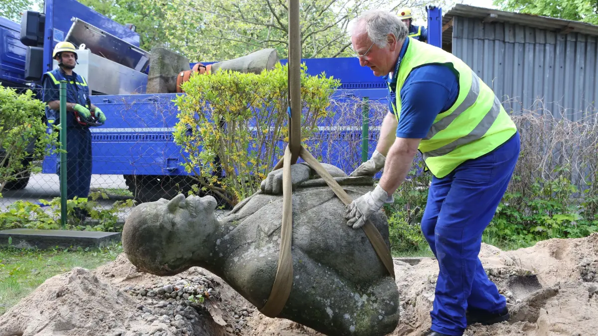 (ohne Überschrift): 040515 Das Strausberger Lenin-Denkmal im Garten des Heimatmuseums wird abtransportiert. Günter Wehr vom Verein IFA-Freunde aus dem Fürstenwalder Ortsteil Trebus befestigt das Oberteil.Im Hintergrund Helfer vom THW.