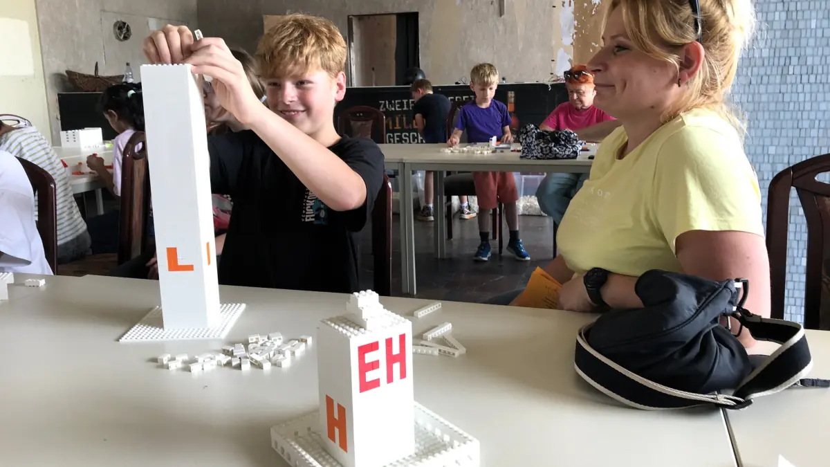 Projekt „Meet’n’Build“ am 17. Juli 2026 in Eisenhüttenstadt. Liam Platkowiack (12) aus Eisenhüttenstadt baut ein Hochhaus, seine Mutter Heike Platkowiack hat ein kleineres Haus bereits fertiggestellt. Foto: Frank Groneberg