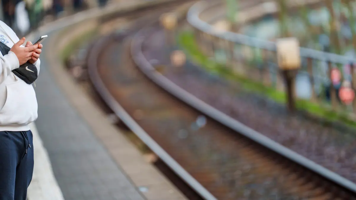 Nahverkehr: ARCHIV - 09.12.2025, Hessen, Frankfurt/Main: Ein Pendler informiert sich am Bahnhof Galluswarte auf seinem Smartphone über Ausfälle und Verspätungen der betroffenen S-Bahnen. (zu dpa: «Überlastete Schienen: Pünktlichkeit von Zügen sinkt weiter») Foto: Andreas Arnold/dpa +++ dpa-Bildfunk +++