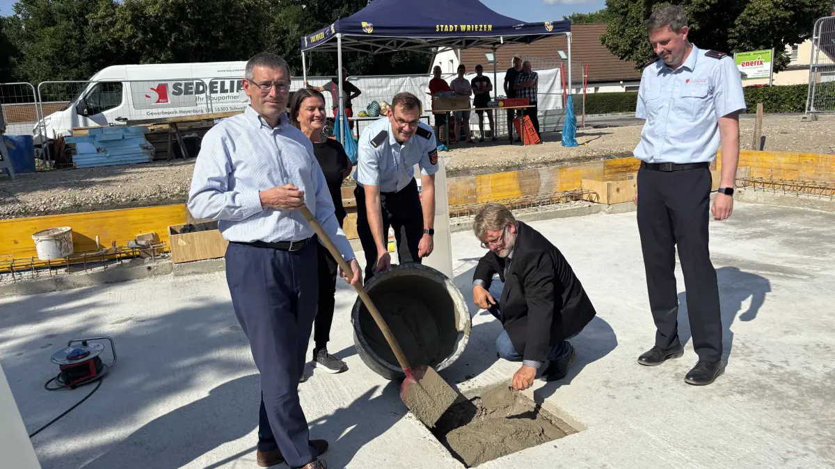 Grundsteinlegung bei Wriezen: Innenstaatssekretär Uwe Schüler, Architektin Oda Formazin, Marton Zohles vom Landkreis MOL, Bürgermeister Karsten Ilm und Ortswehrführer Marcus Klemke (v.l.) betonieren die Schatule ein.