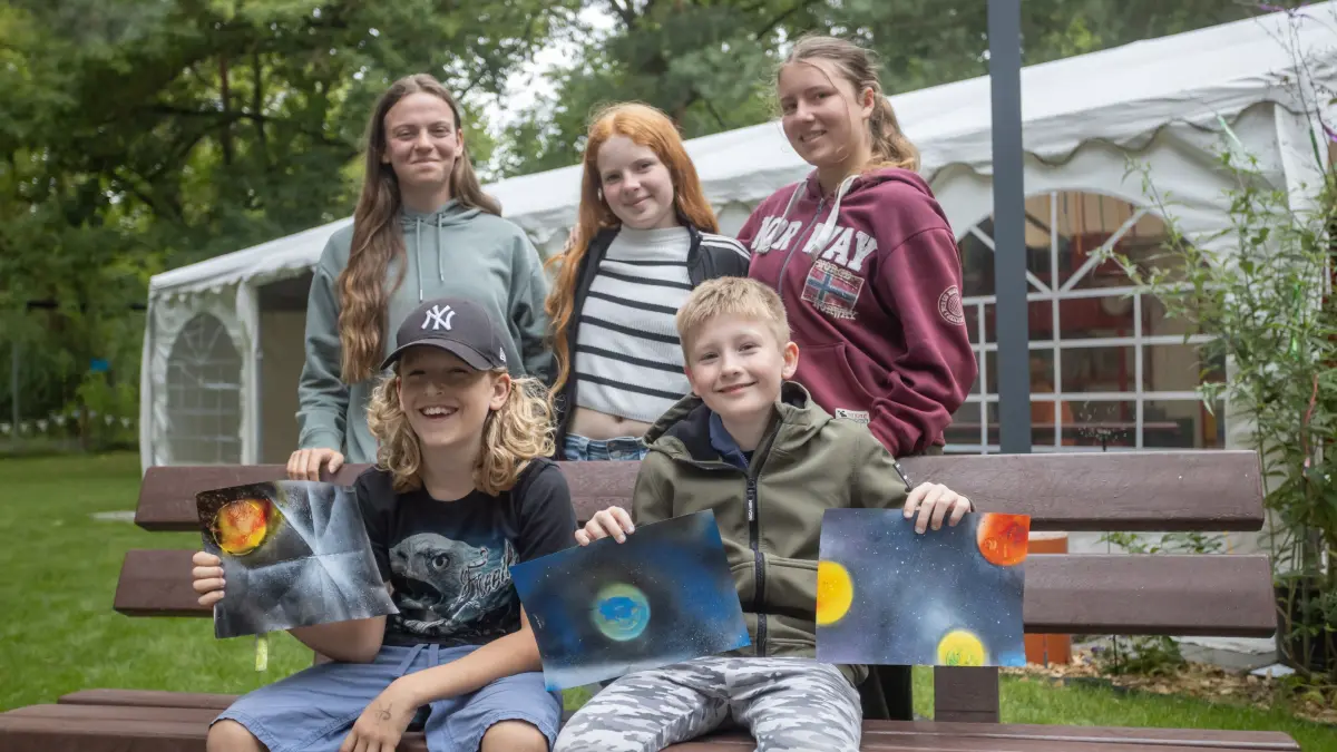 Hannibal (l.) und Till präsentieren ihre Graffiti Kunstwerke die sie erstellt haben. Marika, Greta und Anouk (h.v.l.) sind Teamerinnen die die Erzieher unterstützen.