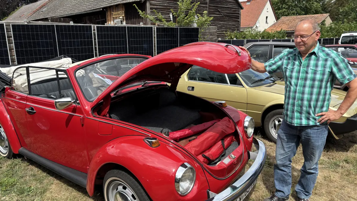 Motor hinten, Kofferraum vorn: Ronald Merten mit seinem knallroten Käfer-Cabrio, Baujahr 1971, beim Oldtimertreffen in Steinhöfel bei Fürstenwalde.