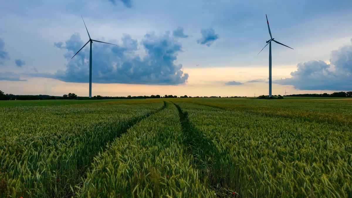 Dunkle Gewitterwolken ziehen über die Landschaft mit Windenergieanlagen im östlichen Brandenburg. Ein Sinnbild? Auch in Oberhavel und Ostprignitz-Ruppin sollen weitere Anlagen entstehen. Das sorgt für Diskussionen.