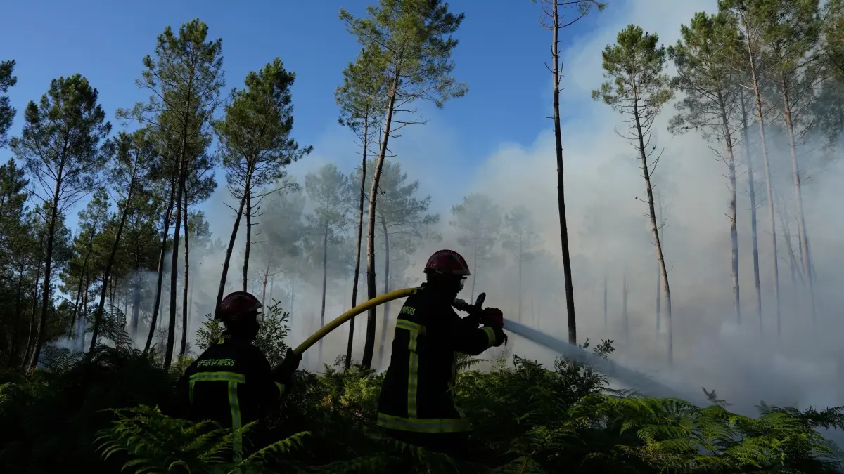 Waldbrände in Frankreich: 27.07.2026, Frankreich, Lacanau: Feuerwehrleute bekämpfen einen Brand in der Nähe von Lacanau, während außerhalb von Bordeaux Waldbrände wüten. Foto: Baz Ratner/AP/dpa +++ dpa-Bildfunk +++