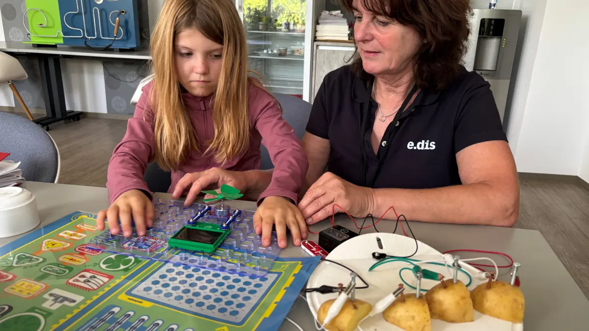 Heike Lewin von der e.dis Netz GmbH in Angermünde führt gemeinsam mit anderen Mitarbeitern Kinder in Angermünde spielerisch in das komplexe Thema Stromerzeugung ein. Mit Marie (8) experimentiert die Kommunalreferentin mit einer Kartoffelbatterie.