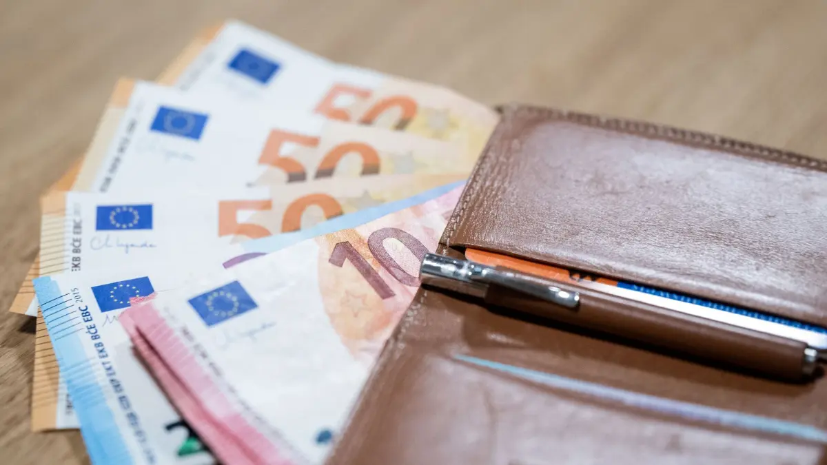 Bargeld: ILLUSTRATION - 24.11.2023, Berlin: Zahlreiche Euro-Banknoten und eine Geldbörse liegen auf einem Tisch. (zu dpa: «Eine Woche Urlaub – zu teuer für jeden Fünften im Südwesten») Foto: Hannes P Albert/dpa +++ dpa-Bildfunk +++