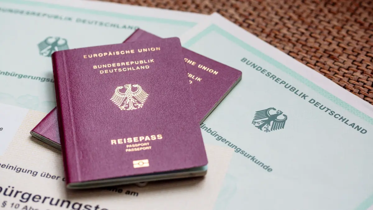 Gefälschte Sprachzertifikate bei Einbürgerungen: SYMBOLBILD - 08.10.2025, Berlin: Zwei deutsche Reisepässe liegen auf Einbürgerungsurkunden der Bundesrepublik Deutschland sowie einem Einbürgerungstest. (zu dpa: «Polizei ermittelt wegen falscher Sprachzertifikate im Allgäu») Foto: Fernando Gutierrez-Juarez/dpa +++ dpa-Bildfunk +++