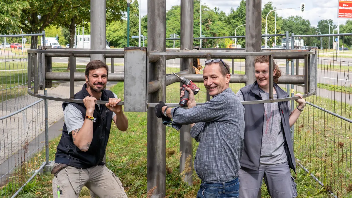 Ringrelief: Thomas Gdanitz Rupnow (Steinfest), Metallbildhauer Hans Hoepfner und Restauratorin Almuth Escher (v.l.) befestigen in Schwedt probehalber die Leiterkonstruktion für das Ringrelief, das derzeit noch aufwendig restauriert wird.