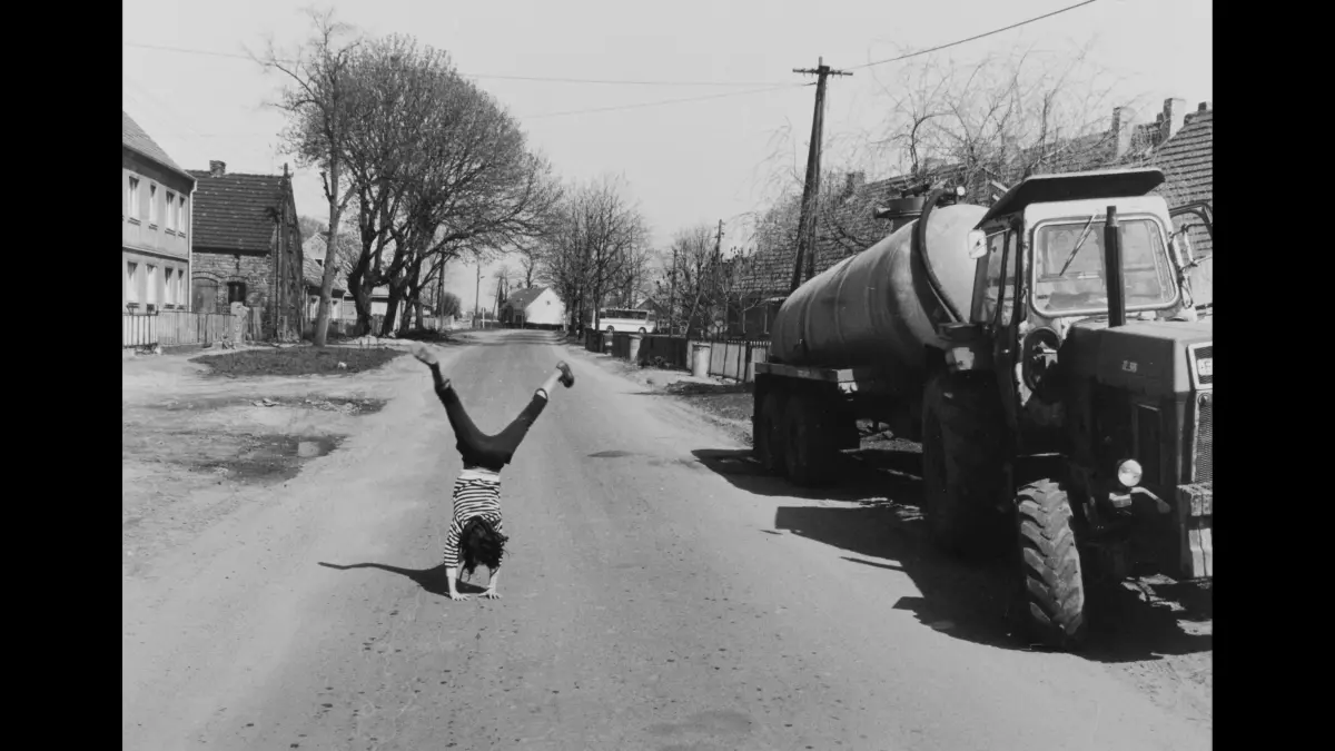 Joachim Richau, Annäherung und Begegnung, Bilder aus Beerfelde, 1984-1987: Ein Mädchen beim Handstand auf einer Dorfstrasse in Beerfelde.