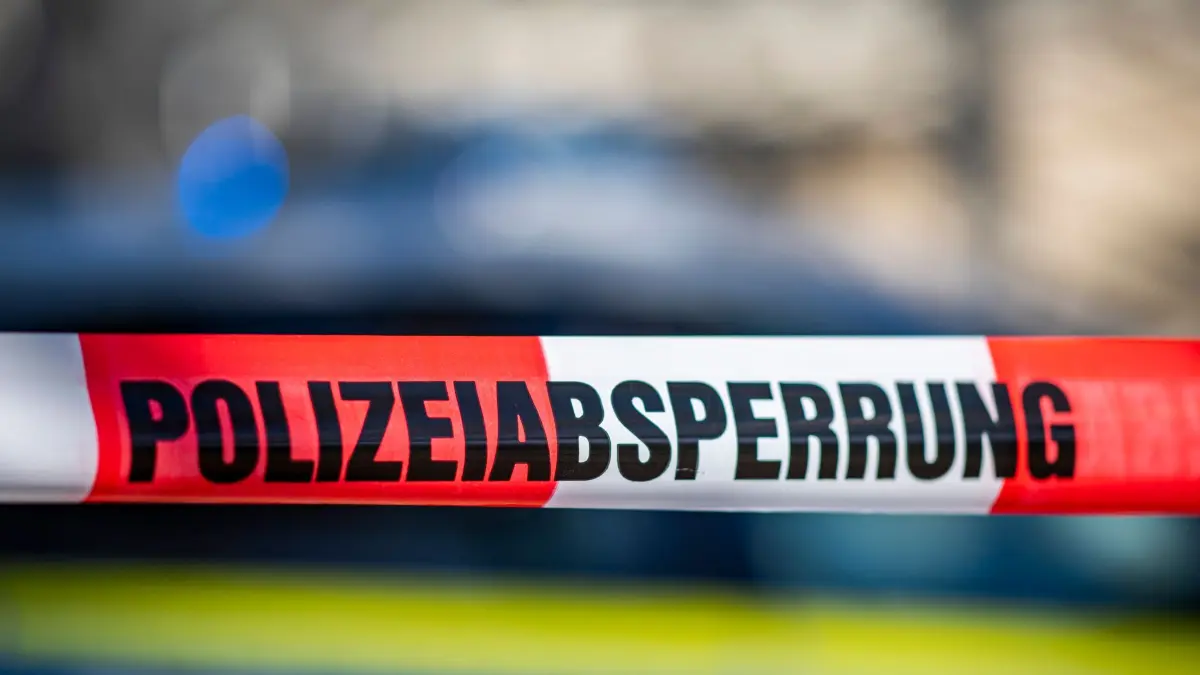 Absperrung der Polizei: ARCHIV - 28.09.2021, Nordrhein-Westfalen, Gütersloh: Ein Absperrband mit der Aufschrift «Polizeiabsperrung» ist vor einem Polizeiwagen aufgespannt. (zu dpa: «Haftbefehl gegen 63-Jährige wegen Mordversuchs») Foto: David Inderlied/dpa +++ dpa-Bildfunk +++