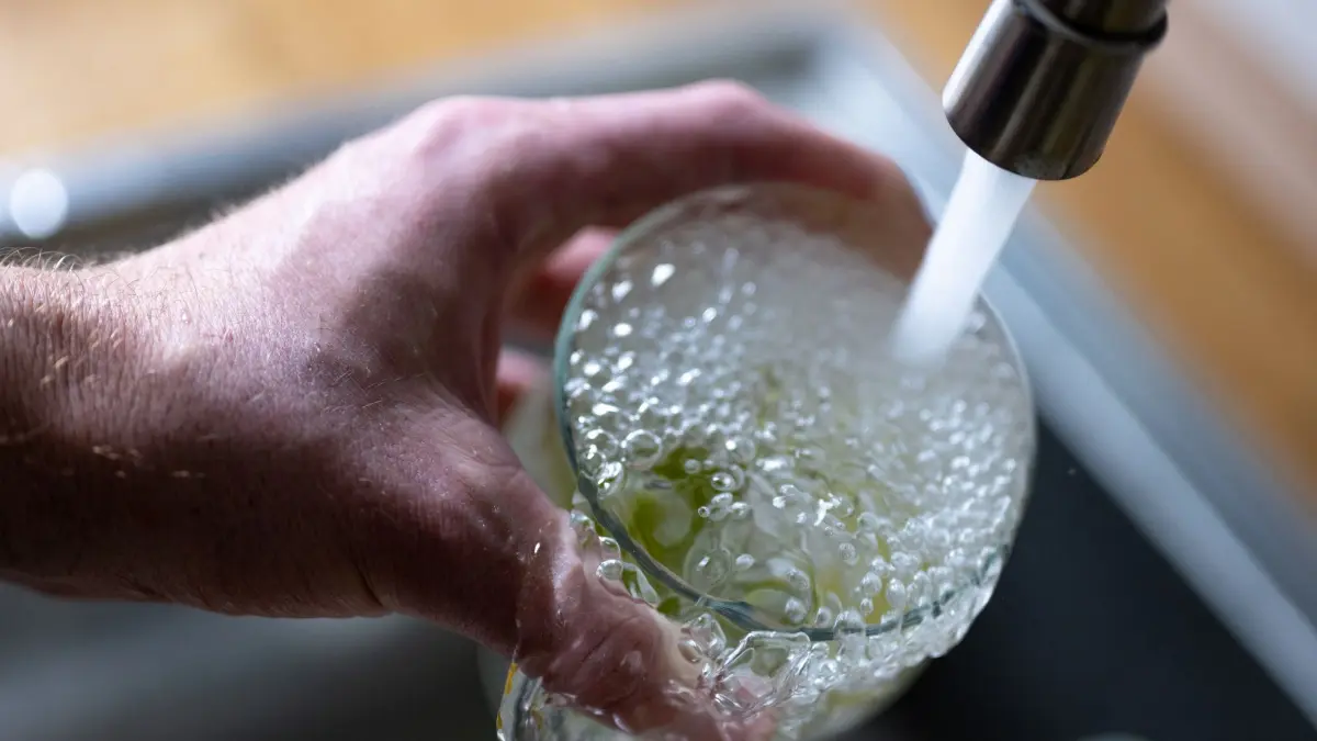 Trinkwasser: ARCHIV - 15.04.2024, Berlin: Tinkwasser läuft aus dem Wasserhahn in einer Küche in ein Glas mit Limettenstücken. (zu dpa: «SPD-Fraktion fordert rasche Landesstrategie zum Wasser») Foto: Monika Skolimowska/dpa +++ dpa-Bildfunk +++
