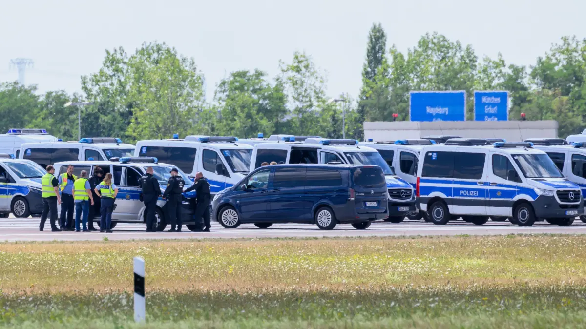 Einsatzkräfte der Polizei am Ende der Start-und-Lande-Bahn Nord des Flughafens Leipzig/Halle