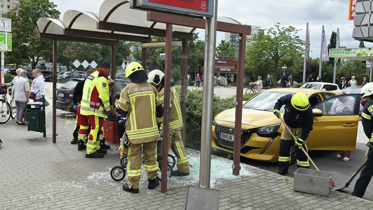Einsatzkräfte beseitigen die Glassplitter, nachdem ein Auto die Bushaltestelle am CKS in Schwedt rammte. Zwei Personen wurden verletzt.