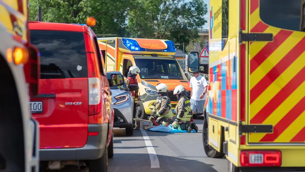 Unfall in Rüdersdorf bei Berlin: Einsatzkräfte der Feuerwehr mussten einen Radfahrer befreien, der unter einem Auto eingeklemmt wurde.