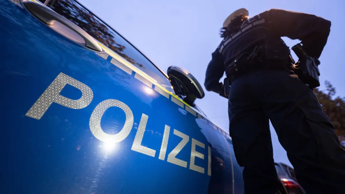 Illustration - Polizei: ILLUSTRATION - 30.11.2023, Baden-Württemberg, Stuttgart: Eine Polizistin steht im Rahmen eines Fototermins neben einem Polizeifahrzeug (gestellte Szene). (zu dpa: «Gefälschte Auto-Inserate: So gehen Betrüger vor») Foto: Marijan Murat/dpa +++ dpa-Bildfunk +++