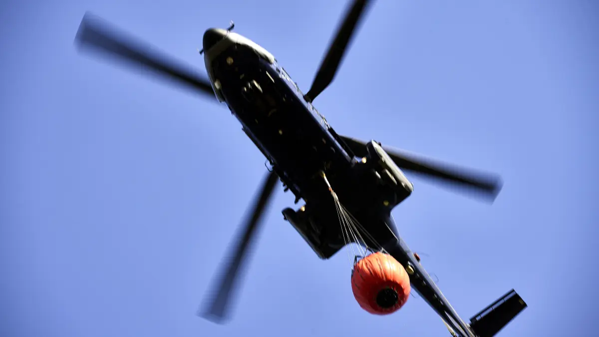 Ein Löschhubschrauber der Bundespolizei im Einsatz bei einem Waldbrand. Wie solche Einsätze verbessert werden können, damit beschäftigt sich unter anderem das Waldbrandkompetenzzentrum (WBZZ). Dieses hat nun einen neuen Leiter. (Archivbild)