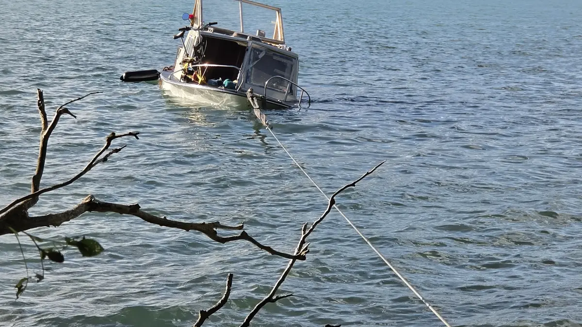 Ein zuvor gekentertes Motorboot hängt am 11.8.2026 an einem Seil am Ufer des Werbellinsees. Die Feuerwehr zog das Boot aus dem Wasser, um es nach einem Unglück zu bergen.