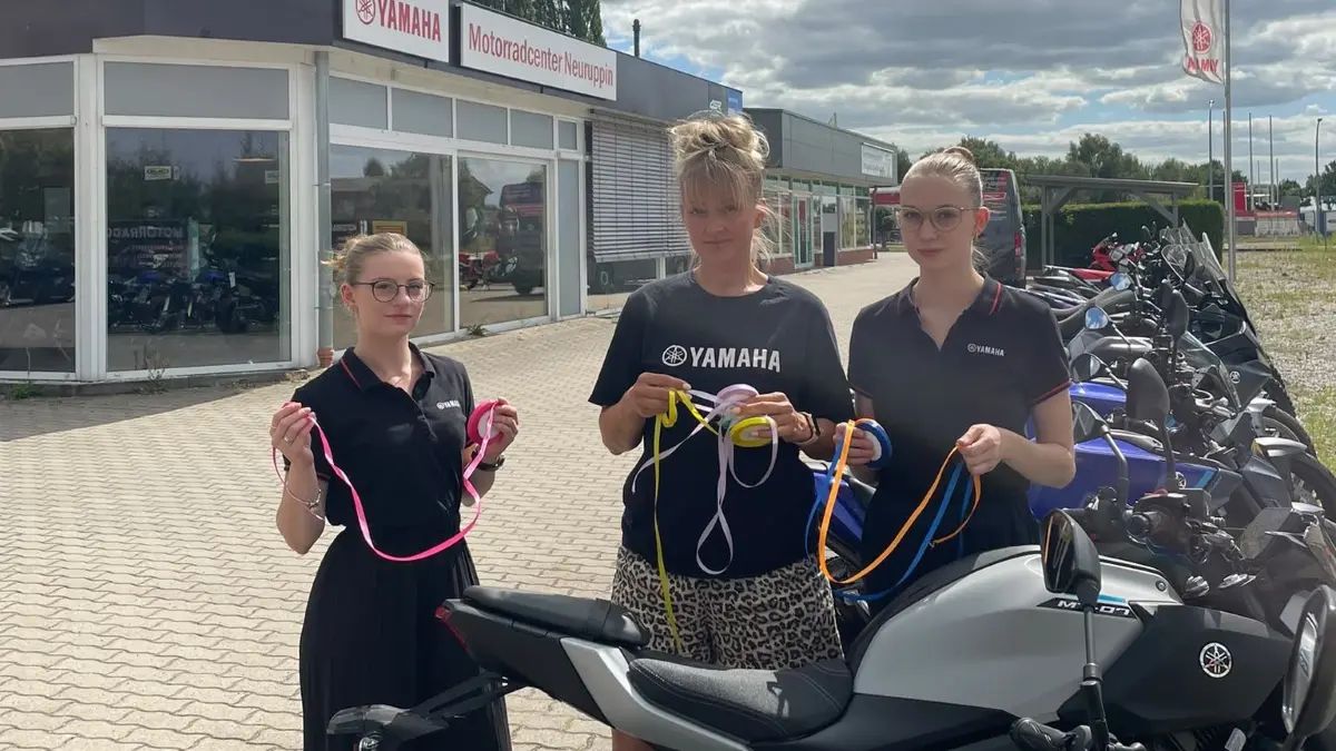Laura-Michelle Wegener (v.l.), Sandra Woratschek und Melissa Lorenz sind Mitarbeiter vom Motorradcenter Neuruppin. Hier beginnt am 15. August die Sternfahrt für die tödlich verunglückte Fahrschülerin Emmi.