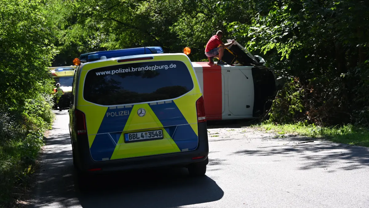 Umgekippter Transporter am Fuchsbau in Petersdorf bei Fürstenwalde: Ein Ersthelfer kletterte auf den Wagen und betreute den Fahrer.
