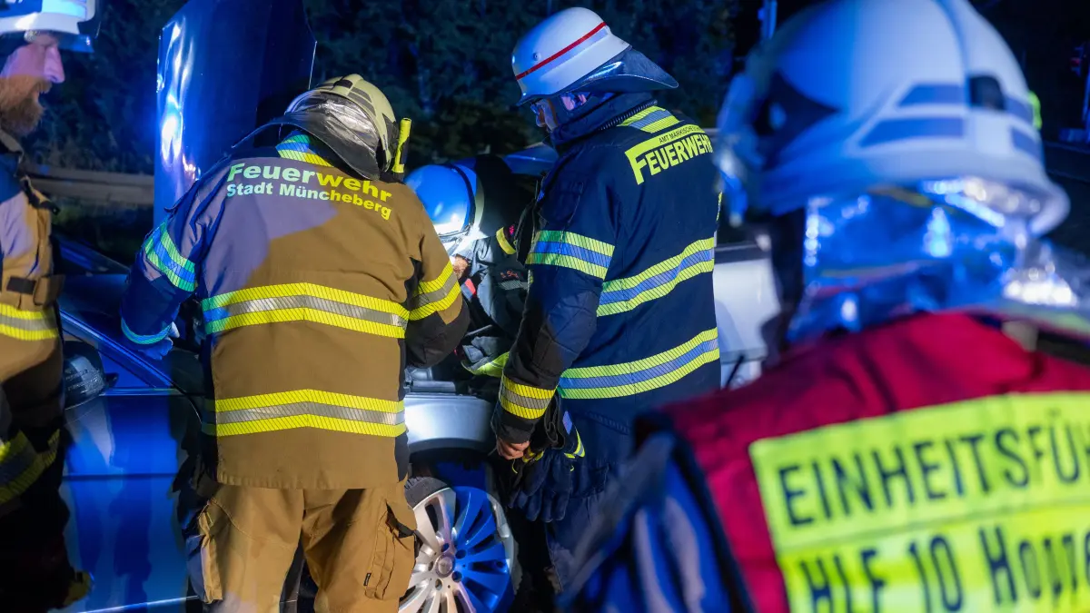 Einsatzkräfte der Freiwilligen Feuerwehr klemmen die Batterien der Unfallfahrzeuge ab.