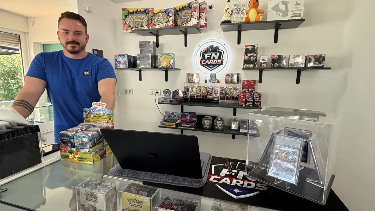 Am beleuchteten Kassenbereich: Fabian Kurzmann hat mit seinem Compagnon Nick in Fürstenwalde das Geschäft FN-Cards eröffnet – für Fans von Sammelkarten, insbesondere Pokémon, One Piece, FIFA und weiteren TCG-Produkten. Warum das auch ein Treffpunkt zum Spielen und Tauschen ist.