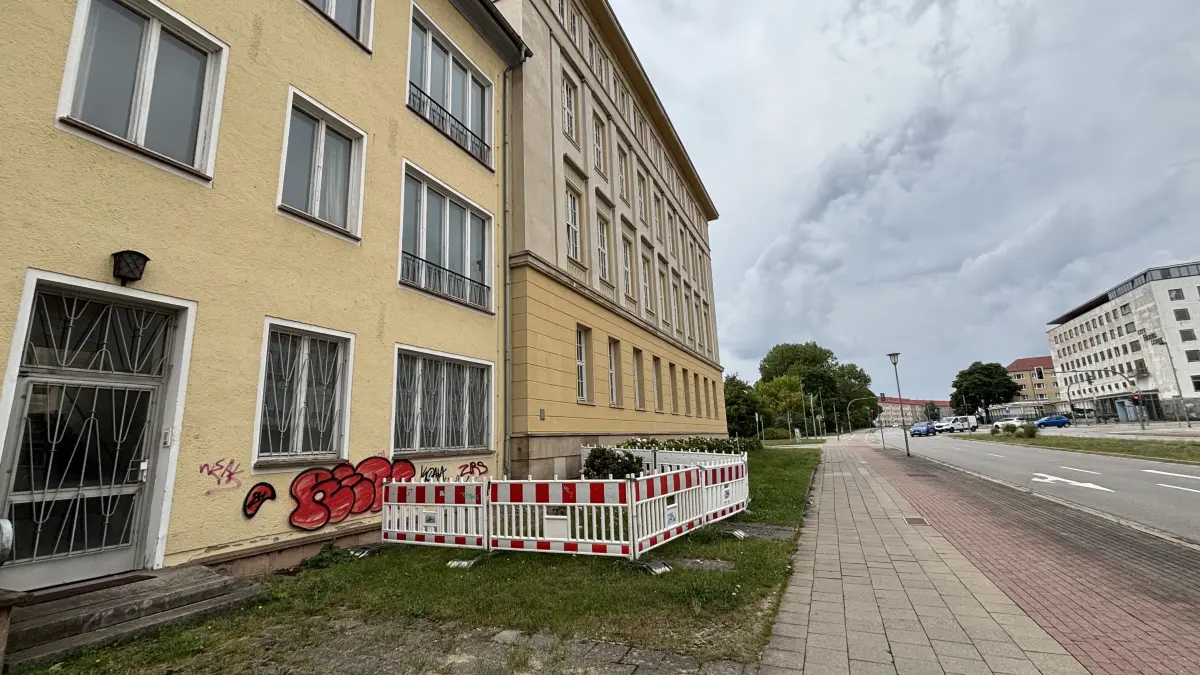 Die Baustellenabsperrung am Rathaus im Bereich der Straße der Republik zeigt. Es gibt Probleme. Die haben auch mit dem Nachbargebäude, der ehemaligen Post zu tun.