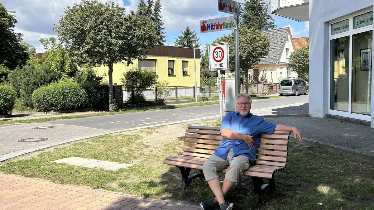 Jürgen Müller auf der Mitfahrbank vor den Räumlichkeiten des Netzwerks Senzig. Eine Idee, um die Mobilität in den Ortsteilen von Königs Wusterhausen zu erhöhen und Lücken im öffentlichen Personennahverkehr zu schließen.