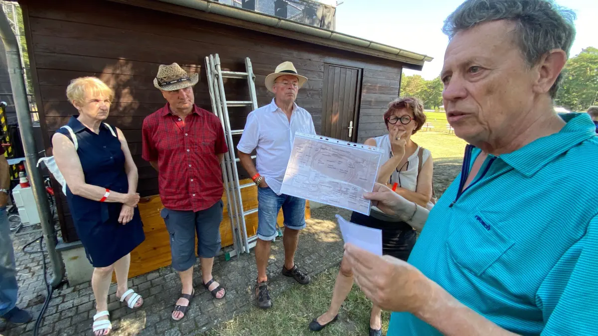 Führung durch Stadion, Arboretum und Ehrenhain: In der Hand hält der Vortragende Vorsitzende der Bürgervereinigung Fürstenberg (Oder), Erich Opitz (rechts), eine Kopie des Planungsvorschlages von 1923.