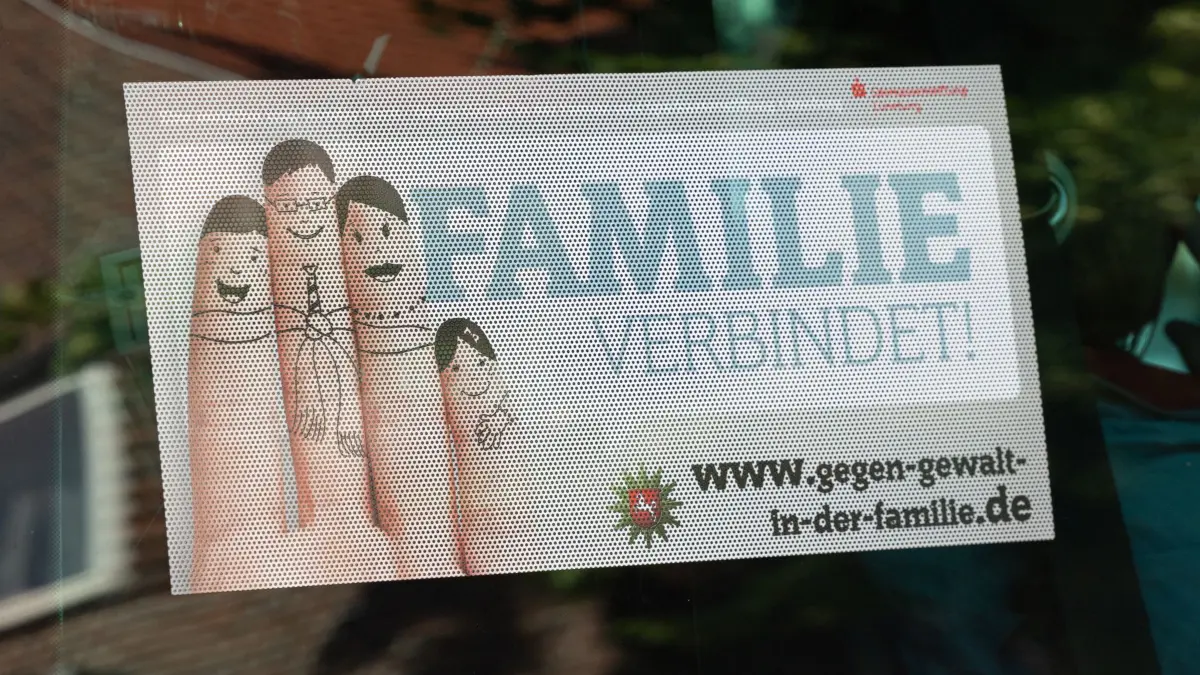 Schüsse in Jugendeinrichtung - Mehrere Tote in Stade: ARCHIV - 29.06.2026, Niedersachsen, Stade: Ein Schild mit der Aufschrift "Familie verbindet!" ist hinter einer Scheibe zu sehen. In der Einrichtung sind mehrere Menschen durch Schüsse gestorben. (zu dpa: «Der Fall Stade – was sich in der Jugendhilfe ändern soll») Foto: Ulrich Perrey/dpa +++ dpa-Bildfunk +++