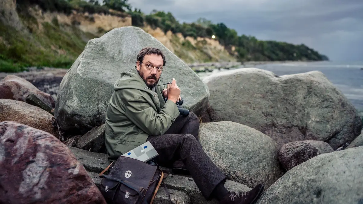 Kinostart - „Spaziergang nach Syrakus“: HANDOUT - 26.07.2026, NA, ---: Paul (Charly Hübner) bei einer seiner Erkundungen an der Ostsee. Szene des Films «Spaziergang nach Syrakus» (undatierte Filmszene). Der Film kommt am 20.08.2026 in die deutschen Kinos. (zu dpa: ««Spaziergang nach Syrakus»: Italien im Kopf, DDR im Rücken») Foto: Sammy Hart/Pandora Film/dpa +++ dpa-Bildfunk +++