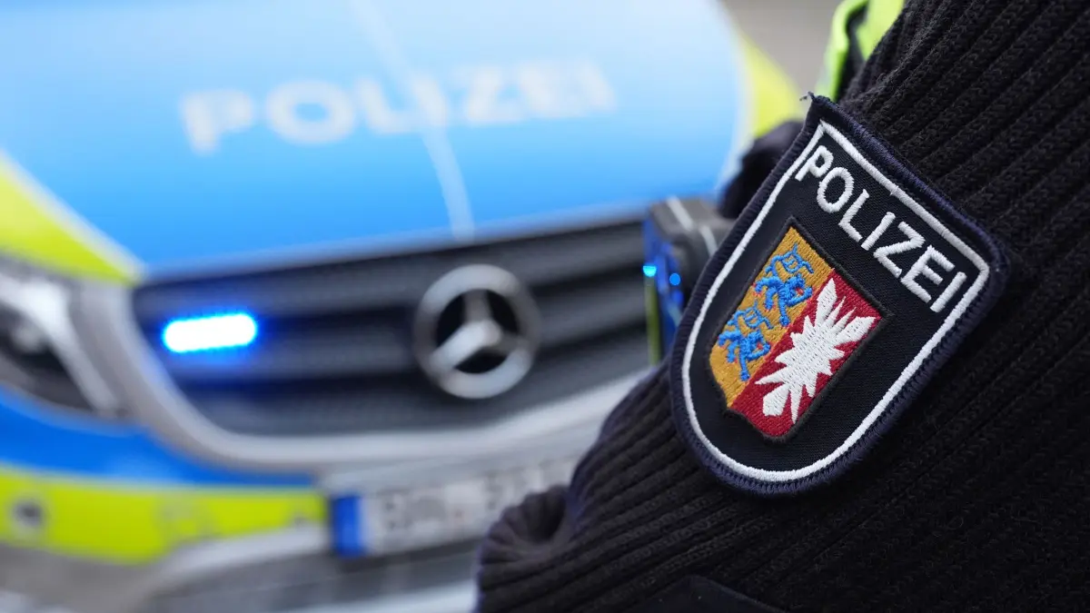 Landespolizei Schleswig-Holstein: ARCHIV - 11.12.2024, Schleswig-Holstein, Kiel: ILLUSTRATION - Das Landeswappen von Schleswig-Holstein und der Schriftzug „Polizei“ sind auf dem Ärmel einer Polizistin vor einem Einsatzfahrzeug auf dem Gelände des Polizeizentrums Eichhof zu sehen. (zu dpa: «A7-Auffahrt nach Lkw-Unfall bei Neumünster gesperrt») Foto: Marcus Brandt/dpa +++ dpa-Bildfunk +++