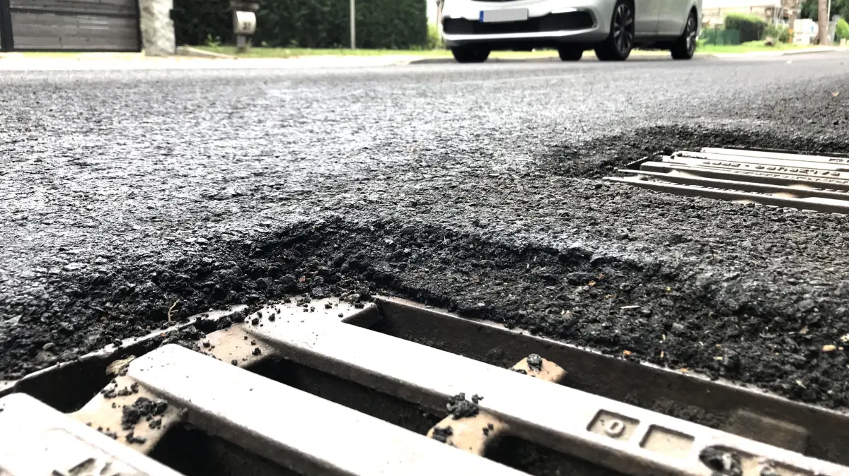 Müllrose. Mixdorfer Straße. Nach dem Aufbringen einer neuen dünnen Asphaltdeckschicht ist der Asphalt auf der Fahrbahn bis zu 3 cm höher als die Gullys und die Schachtabdeckungen. Gefährlich kann das vor allem für Zweiradfahrer sein. 21.08.2026 Foto: Frank Groneberg