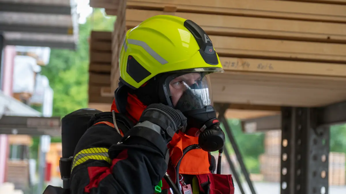 Unter schwerem Atemschutz mussten die Einsatzkräfte in die verrauchte Lagerhalle, um eine Person zu retten.
