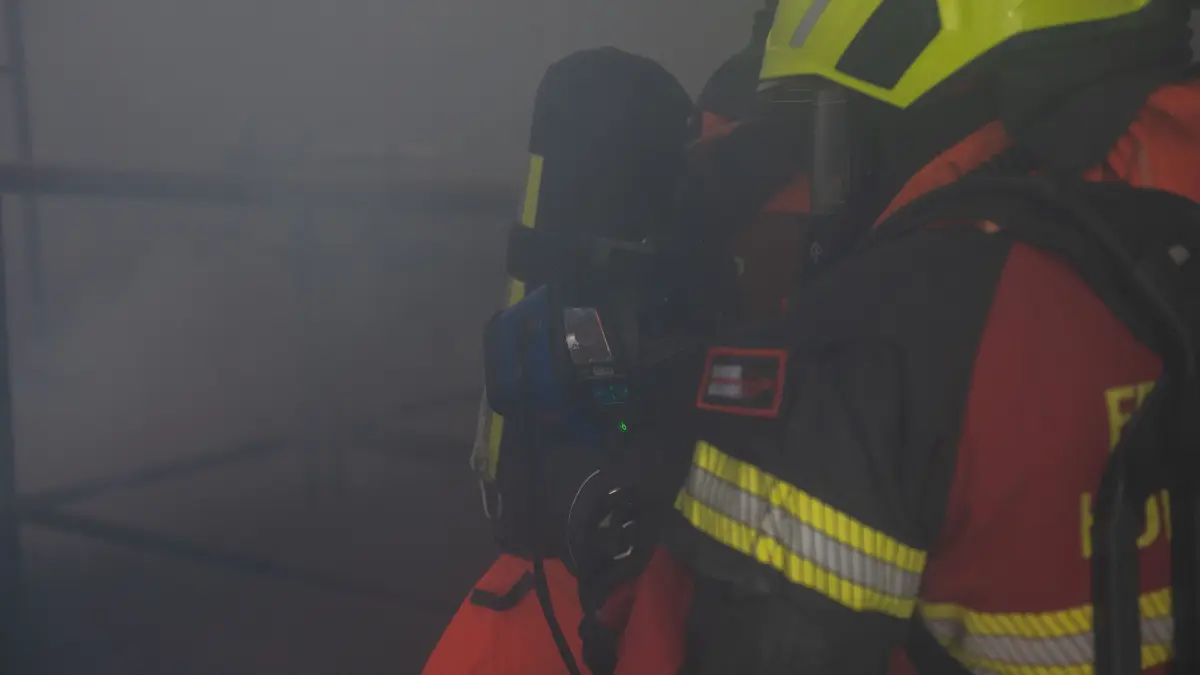Bei nahezu null Sicht orientieren sich die Rettungskräfte mit einer Wärmebildkamera durch das Gebäude.