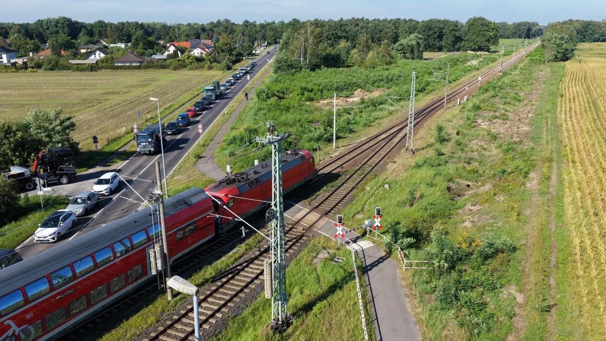 DB Zweites Gleis Vorb: Im Bild: Bahnübergang Kolkwitz
Luftaufnahme vom 25. August 2026
Der Bau des zweiten Gleises auf der Strecke zwischen Cottbus und Lübbenau steht unmittelbar bevor. Gleich hinter dem Bahnübergang Kolkwitz, Berliner Strasse wurden bereits Abholzarbeiten für den zweigleisigen Ausbau der Bahnstrecke Cottbus-Lübbenau durchgeführt.
Die Bahnstrecke zwischen Cottbus und Lübbenau bekommt ein zweites Gleis: Damit soll der Schienenverkehr zwischen Cottbus und Berlin zukünftig schneller und zuverlässiger werden.
Innerhalb von zwölf Monaten soll der neue Schienenabschnitt unter Vollsperrung fertig ausgebaut werden. Ab Dezember 2026 sollen die Bauarbeiten am Gleis samt Sperrung beginnen
Die ersten Bauarbeiten hatten schon im Jahr 2025 stattgefunden. Sie umfassten Umweltmaßnahmen und den Aufbau von Amphibien- und Reptilienschutzzäunen. Im Herbst 2025 begannen Baumfällungen entlang der Strecke, um Platz für die künftigen Gleise zu schaffen. Vor der Sperrung der Strecke zwischen Cottbus und Lübbenau müssen noch weitere Vorbereitungsmaßnahmen durchgeführt werden: Baustraßen, Baueinrichtungsflächen und temporäre Kabelkanäle zur Stromversorgung der Maschinen müssen errichtet werden.
Im Jahr 2027 laufen dann die Maßnahmen für den Bau des zweiten Gleises, die bis Ende des nächsten Jahres abgeschlossen werden sollen.
Zwischen der Lausitz und der Bundeshauptstadt wird dann ein Halbstundentakt möglich sein und auch die Kapazitäten für den Güterverkehr der Wirtschaft werden dadurch erhöht.